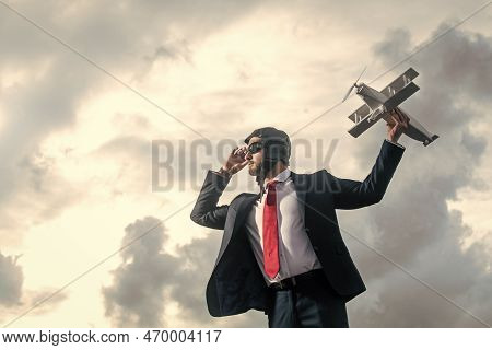 Businessman In Suit And Pilot Hat Launch Plane Toy. Foresight