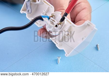 Assembly Of Folding Electrical Plug For An Electrical Cord, An Electrician Assembles Plastic Electri