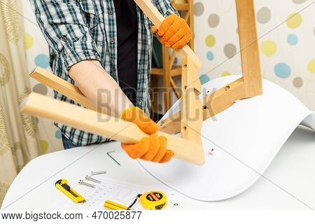 Self-assembly Furniture Concept. The Young Man Himself Assembling Chairs