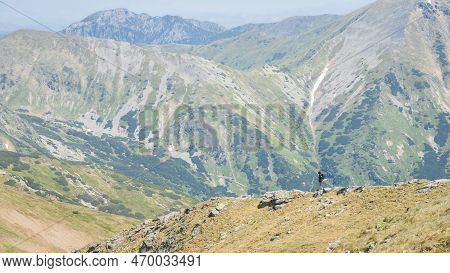 Male Hiker With Backpack Walking Down The Ridge Amongst Big Mountains , Eu, Slovakia.