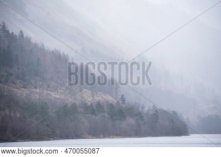 Beautiful Calm Peaceful Winter Landscape Over Thirlmere In Lake District With Fog And Layers Of Tree