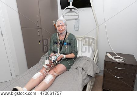 Middle Aged Woman Measuring Brain Waves, Examining Polysomnography In Sleep Lab