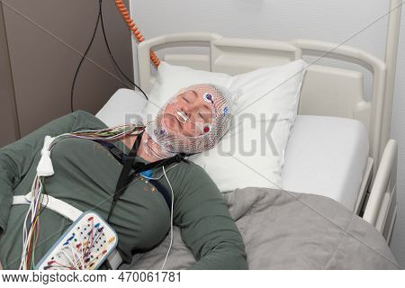 Middle Aged Woman Measuring Brain Waves, Examining Polysomnography In Sleep Lab