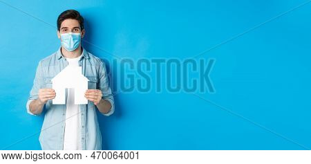 Concept Of Coronavirus, Quarantine And Social Distancing. Young Man Searching Apartment, Showing Hou