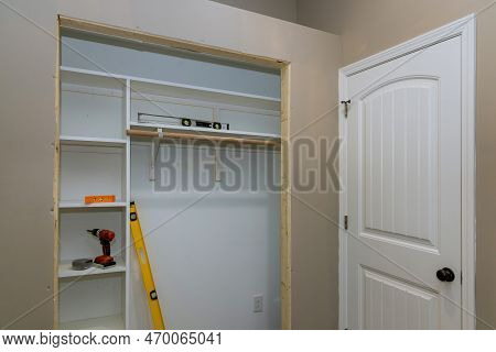 Installation Of An Interior White Melamine Shelf To Be Used To Store Clothing, With Many Empty Shelv