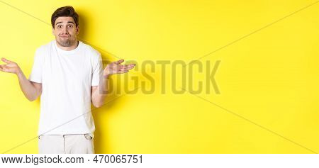 Clueless Man Shrugging, Spread Hands Sideways Confused, Dont Know Anything, Standing Over Yellow Bac