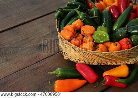 Many Different Fresh Chilli Peppers On Wooden Table, Space For Text