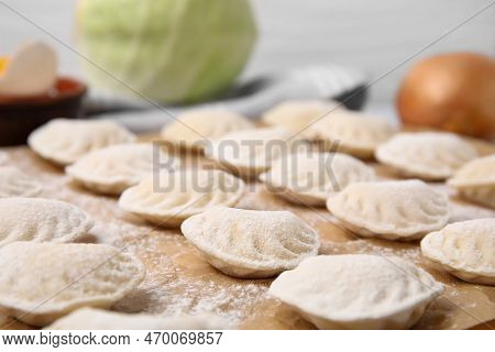 Raw Dumplings (varenyky) With Tasty Filling And Flour On Parchment Paper, Closeup View