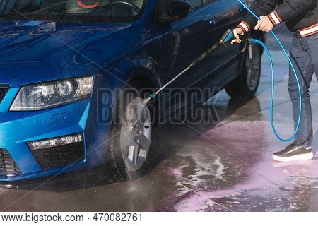 Process Of Cleaning Car With A Jet Sprayer. Self Service Car Washing. Close-up Of Man Wash Wheels