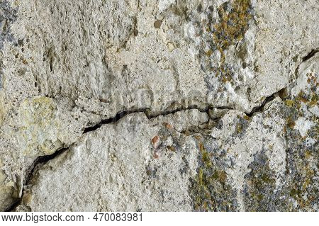 Big Deep Ascending Crack On Old Moss-covered Wall. Close-up. Copy Space. Selective Focus.