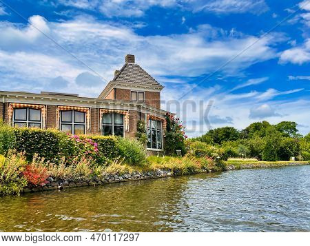 Voorburg, Netherlands - June 19 2022: Old Historic Dutch House Build Along A Canal With A Blue Vibra