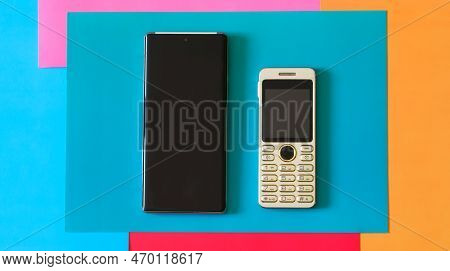 Small Push-button Mobile Phone Compared To A Modern Smartphone. Comparison Of The Sizes Of Mobile De