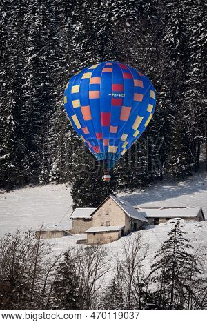 Chateau-d'oex,vaud, Switzerland - 23 January 2023: Hot Air Balloon Flying Over The House. Hot Air Ba
