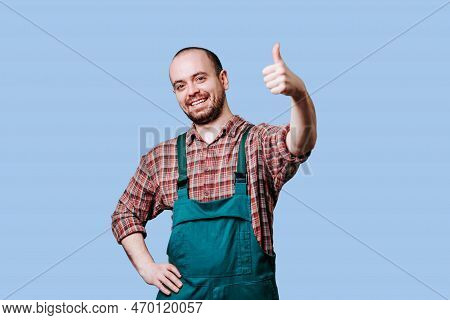 Joyful Farmer With Thumbs Up And Looking At Camera, In Studio Contented Farmer In Blue Studio Shot, 