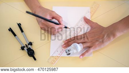 Female Hand Using A Ruler With The Pencil Preparing To Draw And Sketch On The Empty White Paper.