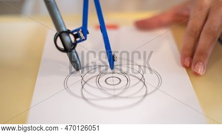 Female Hand Using A Measure Circle Preparing To Draw And Sketch On The Empty White Paper.