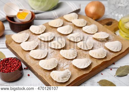 Raw Dumplings (varenyky) With Tasty Filling And Ingredients On White Wooden Table