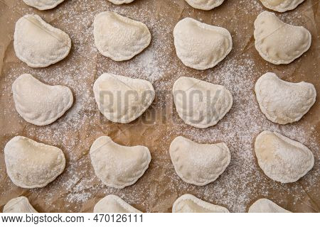 Raw Dumplings (varenyky) With Tasty Filling And Flour On Parchment Paper, Top View
