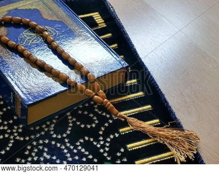 Islamic Concept. Al Quran And Rosary Beads On Prayer Mat.