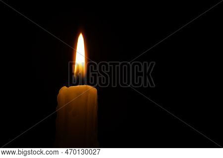 Burning Candle Against A Black Background With Free Copy Space For Text
