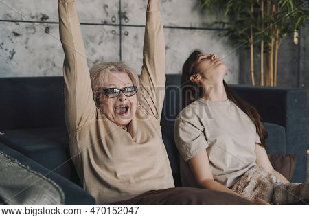 Excited Gamer Senior Woman Playing Video Games, She Is Holding A Controller Making Winnner Gesture. 