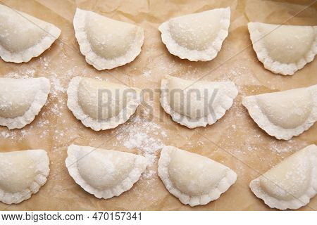 Raw Dumplings (varenyky) With Tasty Filling And Flour On Parchment Paper, Flat Lay