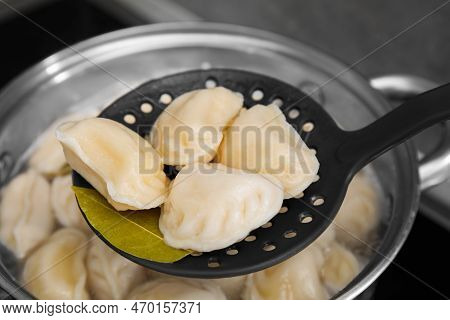 Dumplings (varenyky) With Tasty Filling On Skimmer Over Pot Indoors, Closeup