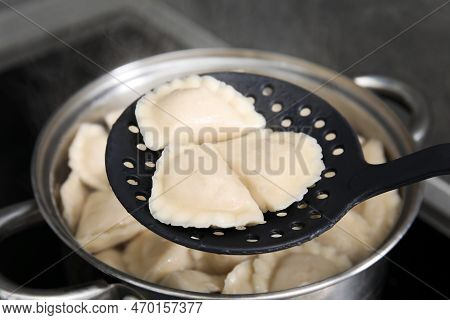 Dumplings (varenyky) With Tasty Filling On Skimmer Over Pot Indoors, Closeup