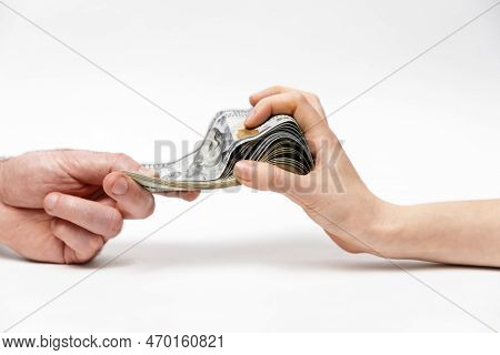 Man's Hand Offers Dollar Bribe To Woman, And She Greedily Reaches For Money. Copy Space. Close-up. C