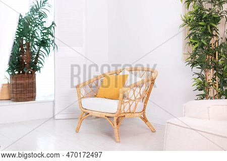 Design Wicker Chair In Stylish Light Bedroom Interior. Rattan Armchair By The White Wall In The Livi