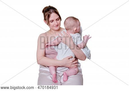 A Mother Woman Holds An Infant Baby To Regurgitate Excess Air After Breastfeeding, Isolated On A Whi