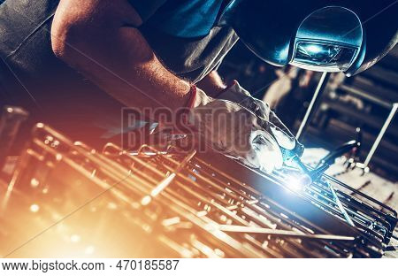 Professional Caucasian Metalworking Worker Welding Metal Pieces. Custom Made Metal Pieces.