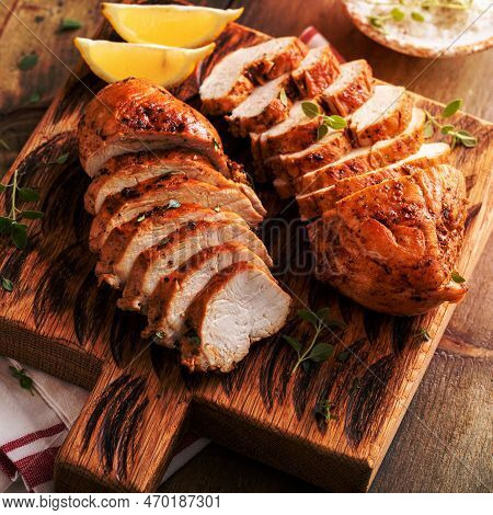 Roasted Or Seared Chicken Breast Sliced On A Cutting Board With Herbs And Spices