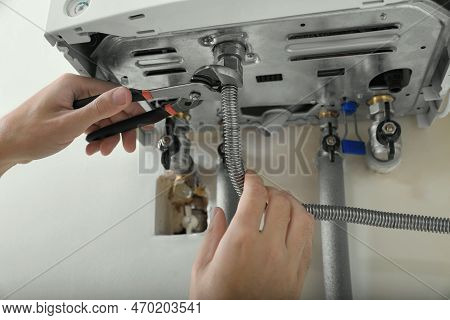 Man Repairing Gas Boiler With Waterpump Plier, Closeup