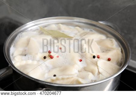 Cooking Dumplings (varenyky) With Tasty Filling, Peppercorns And Bay Leaf In Pot Indoors, Closeup