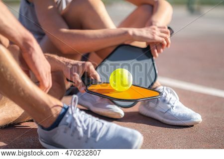 Pickleball Game, Relaxing Pickleball Players Couple With Yellow Ball With Paddle Sitting After Game,