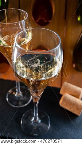 Glasses Of Sparkling White Wine Champagne Or Cava With Bubbles And Classic Wooden Champagne Pupitre