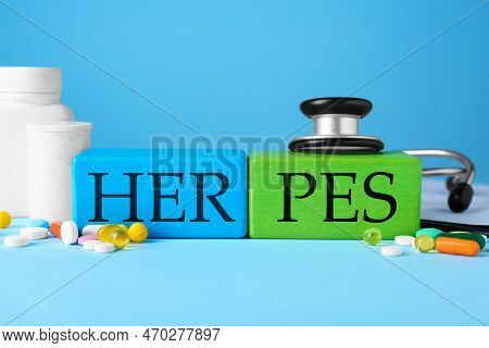 Word Herpes Made Of Colorful Cubes, Different Pills And Stethoscope On Light Blue Background