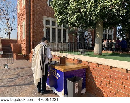 Kfar Chabad, Israel - January 25, 2023: Religious Jew In A Tallit Next To A Donation Box