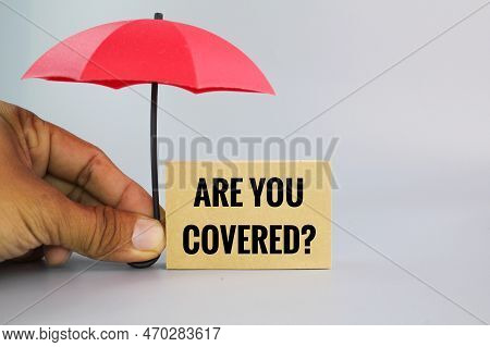 Hand Holding An Umbrella With The Question Are You Covered?. Insurance Coverage Concept