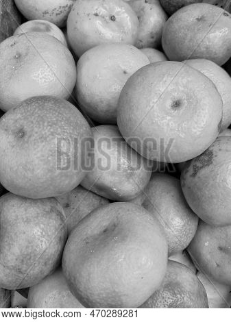 Black And White Yellow And Orange Colored Orange Fruits On Sale In A Market Stall