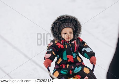 Little Girl Sledging Downhill An Having Fun. Pink Sledge And Jacket, Colorful Scarf.