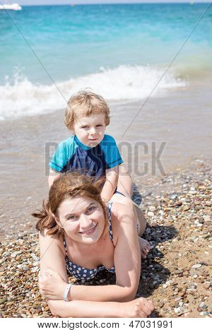 Genç anne ve küçük oğlu kumsalda eğleniyor