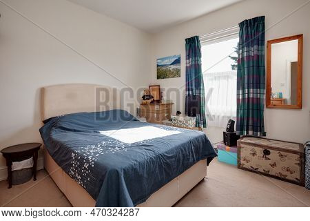 Cambridge, England - August 31 1018: Traditional Furnished Bedroom With Sunlight And Blue Duvet