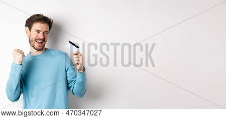 Happy Man Dancing With Plastic Credit Card, Smiling And Saying Yes, Celebrating On White Background