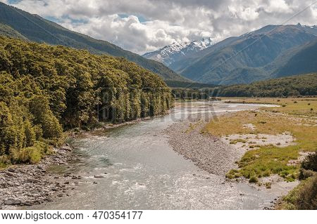 The Makarora River In The Otago Region Of New Zealand Flowing Towards Wanaka Lake With Snow Capped M