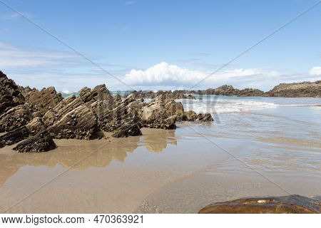 The View Of Marine Landscape. Rocks And Sea Waves In A Sunny Day. Mangawhai Cliff Walk, New Zealand.