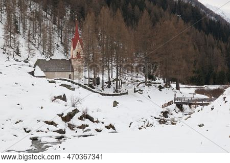 Idyllic Alpine Landscape With Little Church Near The River With Snow