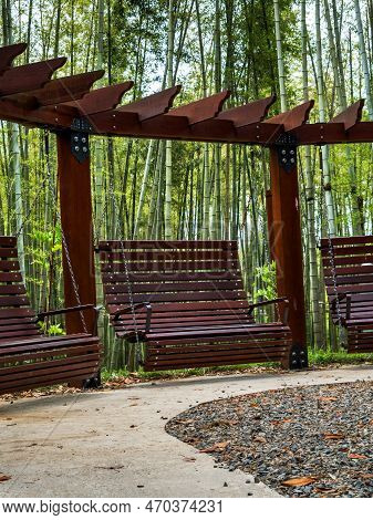 Beautiful Identical Wooden, Hanging, Garden Swings On A Chain In Landscape Design In A City Park. In