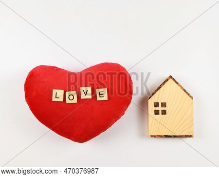 Top View Or Flat Layout Of Wooden Model House And Red Heart Shape Pillow With Wooden Letters L O V E